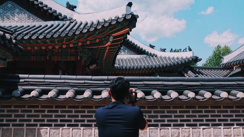 Rear view of man standing at temple