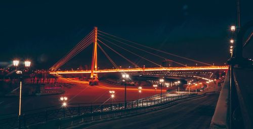 Illuminated bridge against sky at night