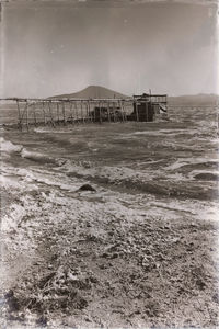 Abandoned building by sea against sky