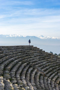 Mid distance view of man standing on steps against sky during winter