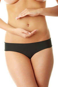 Midsection of woman standing against white background