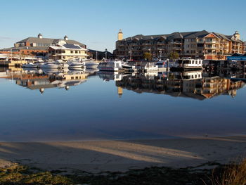 Buildings by lake against sky in city