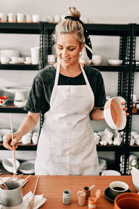 Young woman standing at table