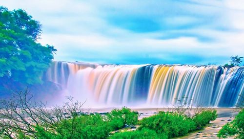 Scenic view of waterfall against sky