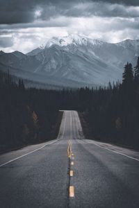 Road leading towards mountains during winter