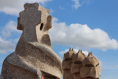 Low angle view of statue against building against sky