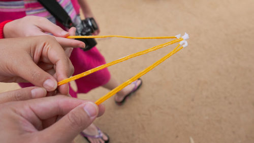 Close-up of hand holding orange wool