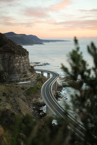 High angle view of road by sea against sky during sunset