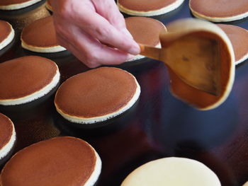 Cropped hand of vendor flipping dorayaki on electric stove