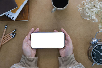 Low section of person with clock on table