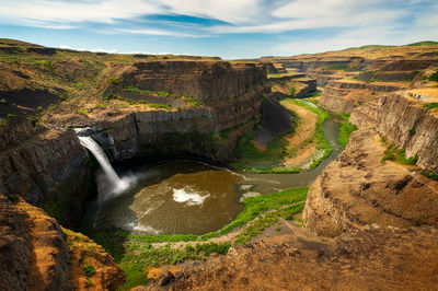 Scenic view of waterfall against sky