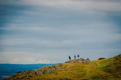 Unrecognizable tourists walking in the holyrood park, edinburgh, scotland