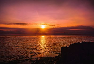 Scenic view of sea against romantic sky at sunset