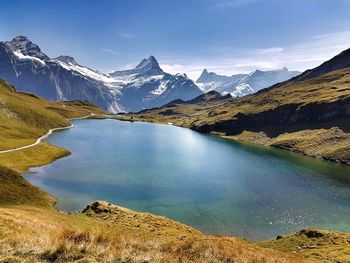 Scenic view of lake by mountains against sky