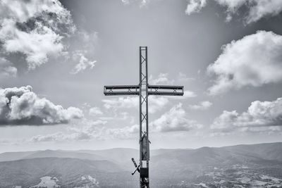 Low angle view of cross on mountain against sky