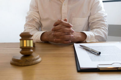 Midsection of man sitting on table