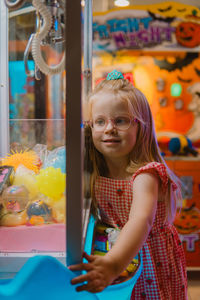 Little girl hugging claw machine