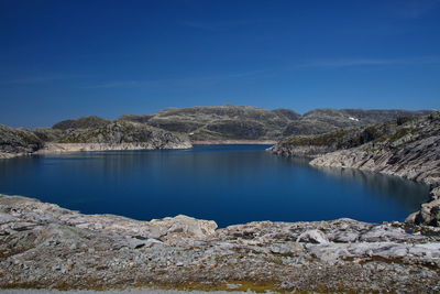 Scenic view of lake against clear blue sky