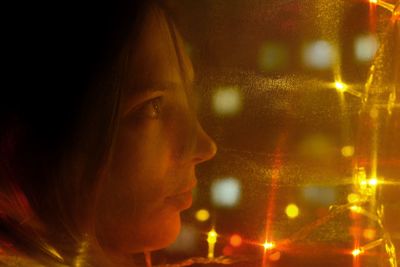 Close-up portrait of woman looking away at night