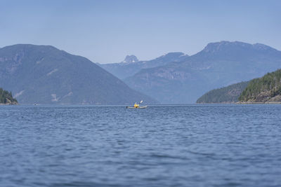 Sailboat in sea against mountains