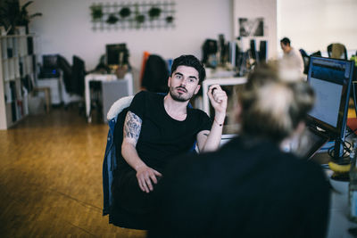 Young man sitting in chair in office