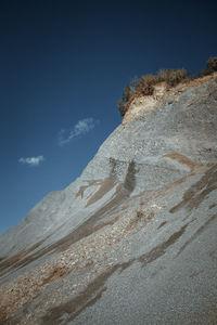 Low angle view of rocky mountain against sky