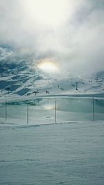 Scenic view of snow covered landscape against cloudy sky