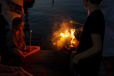 People sitting by bonfire