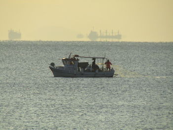 Boat sailing in sea against clear sky