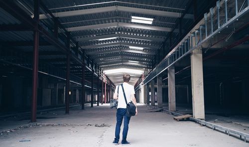 Full length rear view of photographer empty warehouse