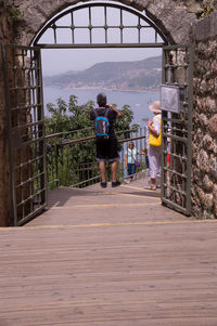 Rear view of people walking on bridge