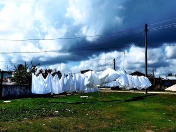 Clothesline in back yard against cloudy sky