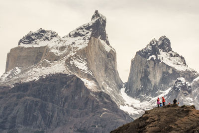 People on snowcapped mountains against sky