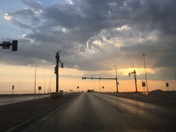 Road by street against sky during sunset