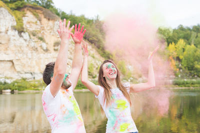 Woman with arms raised while standing in park