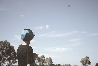 Low angle view of woman standing against sky