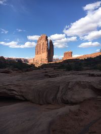 Rock formations on landscape against cloudy sky