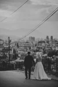 Rear view of couple walking against sky