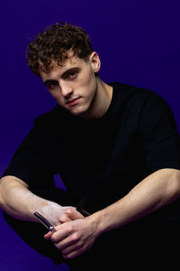 Portrait of young man against black background