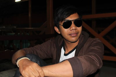 Portrait of young man sitting in sunglasses