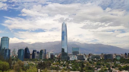 Buildings in city against cloudy sky