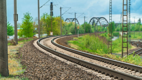 Railroad tracks by trees against sky