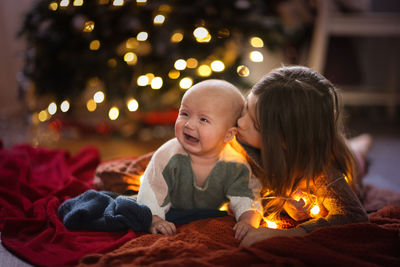 Girl and a younger sister, the baby is crying, and her sister feels sorry for her and comforts her.