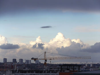 Cranes in city against sky