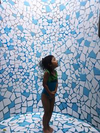 Full length of girl standing in tiled room