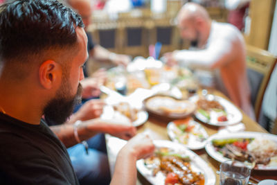 Midsection of man eating food in restaurant