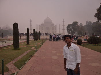 Tourists at temple against sky