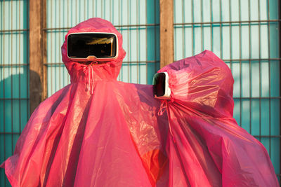 Friends wearing pink raincoat and virtual reality stimulators