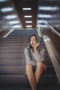 Portrait of young woman standing on steps