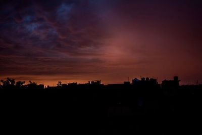 Silhouette city against sky during sunset
